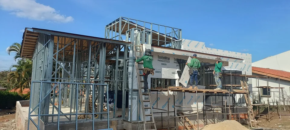 Perfis de Steel Frame montados na fachada, com equipe trabalhando na obra